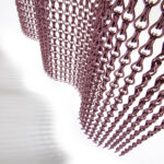Chainlink curtain mesh in copper finish hanging as an architectural curtain