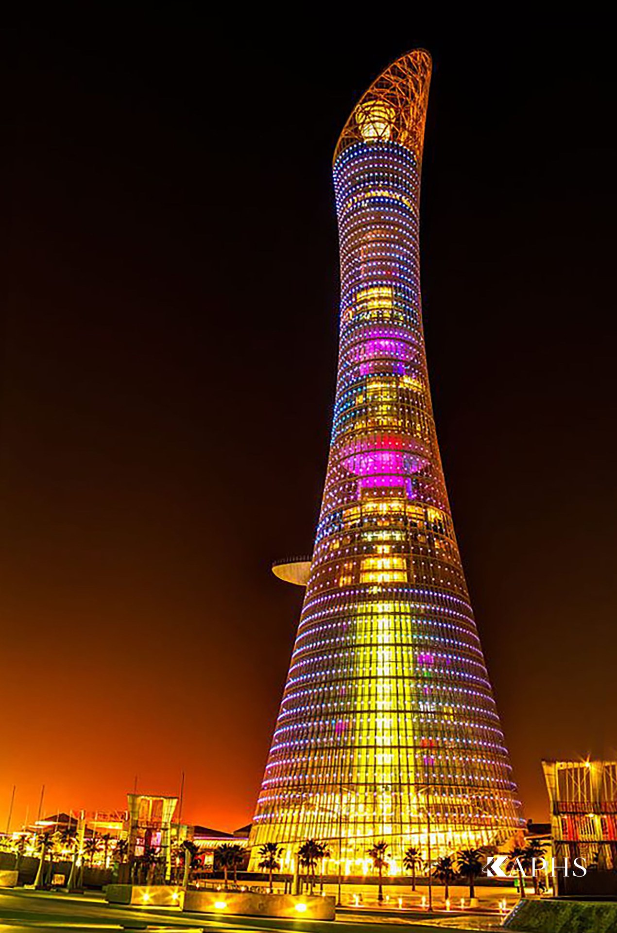 Aspire Torch Tower illuminated at night with programmable LED colour through the wire mesh, Doha — KAPHS