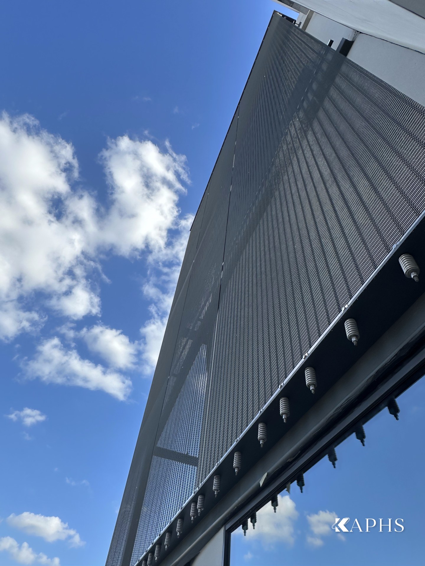 Angled view of the grey architectural wire mesh façade, Mercedes-Benz d3 showroom Dubai — KAPHS