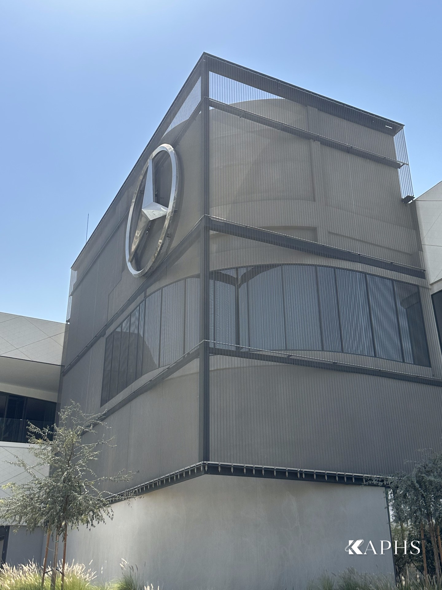 Mercedes-Benz star framed by grey architectural wire mesh, Dubai showroom — KAPHS