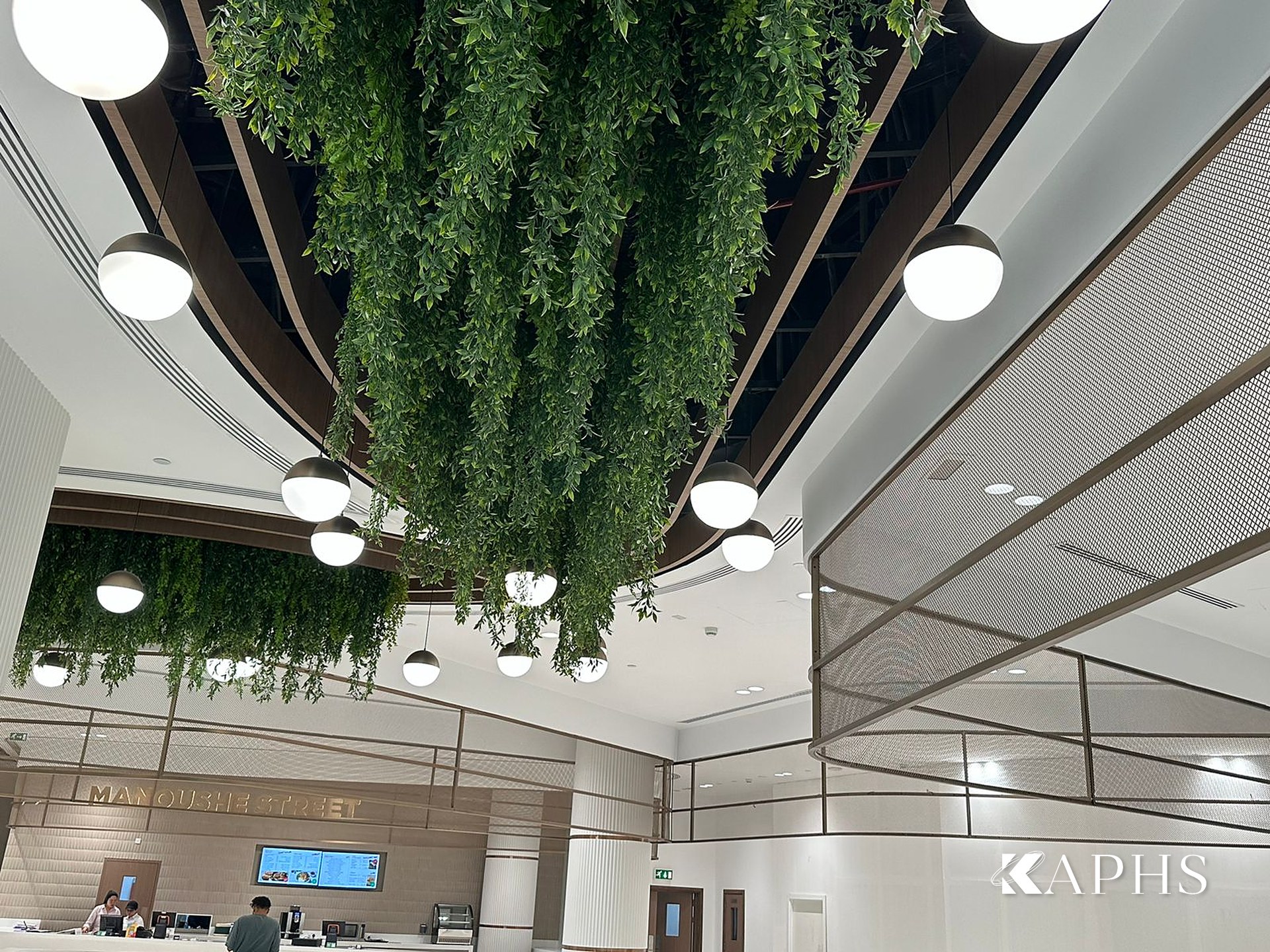 Bronze decorative wire mesh ceiling feature with greenery, DAFZA Food Court Dubai — KAPHS