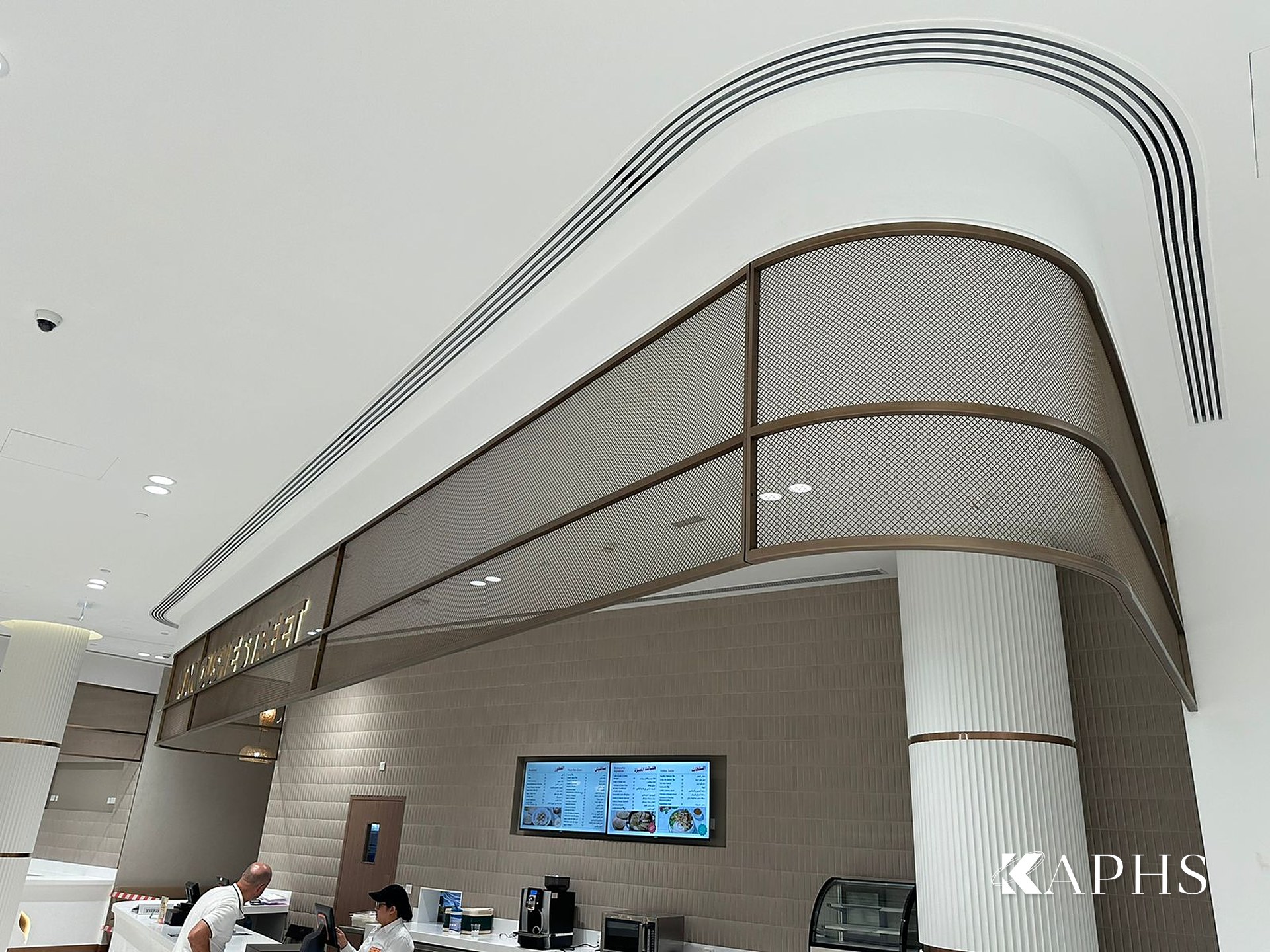 Sculptural bronze decorative wire mesh soffit above a servery, DAFZA Food Court Dubai — KAPHS