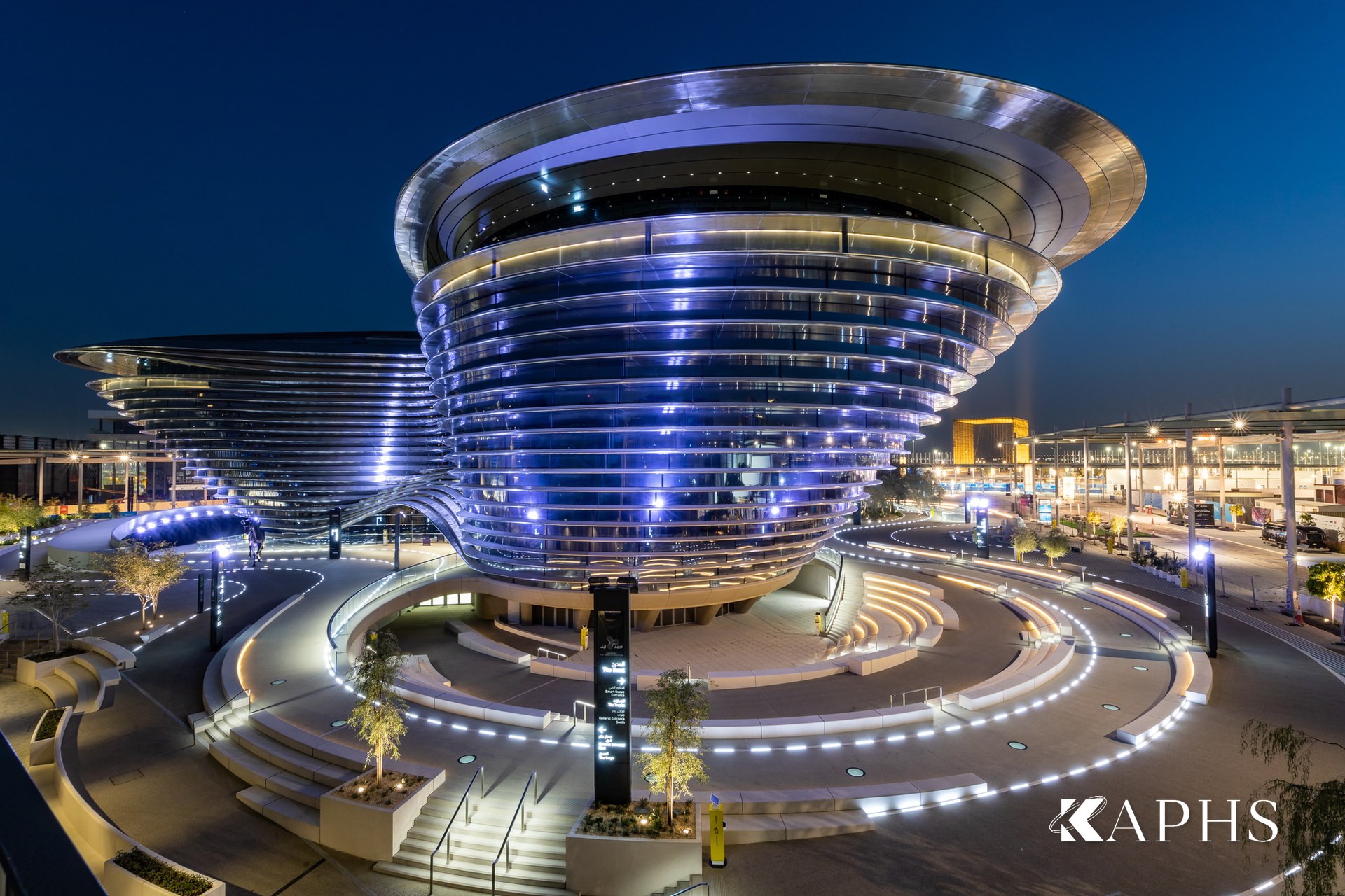 The Mobility Pavilion illuminated at night behind curved NorthGlass jumbo glass, Dubai — KAPHS