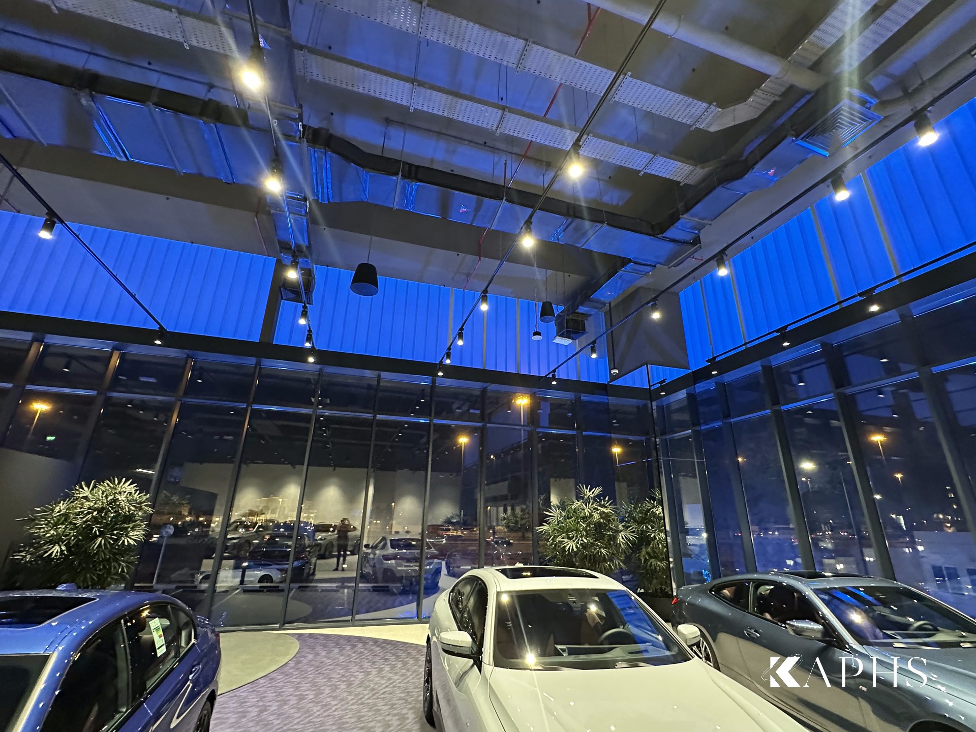 Interior of the AGMC BMW showroom, Sharjah — translucent LINIT U-channel glass clerestory over the display floor, KAPHS