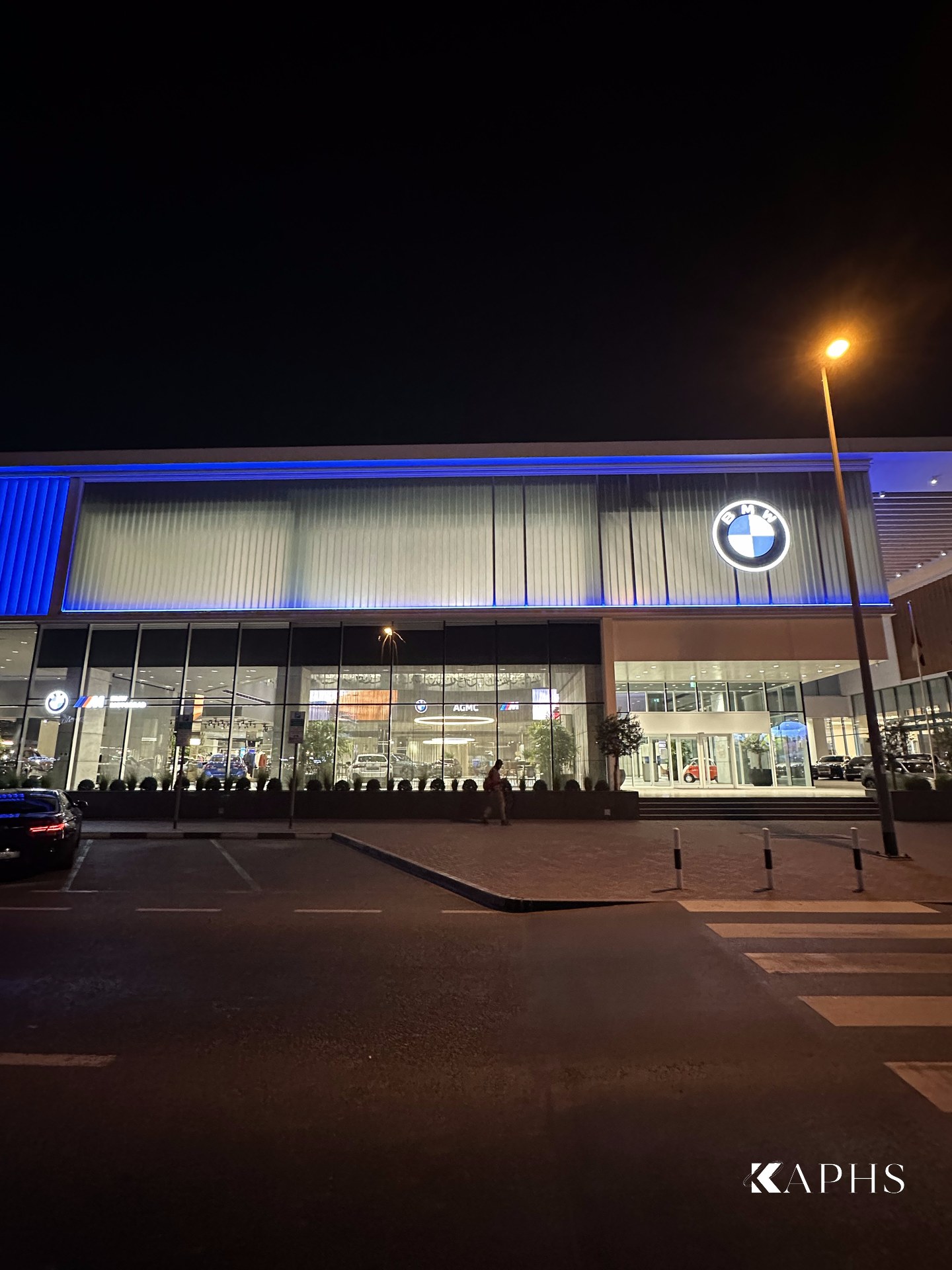 AGMC BMW showroom, Sheikh Zayed Road — illuminated LINIT U-channel glass façade band above the glazed entrance at night, KAPHS