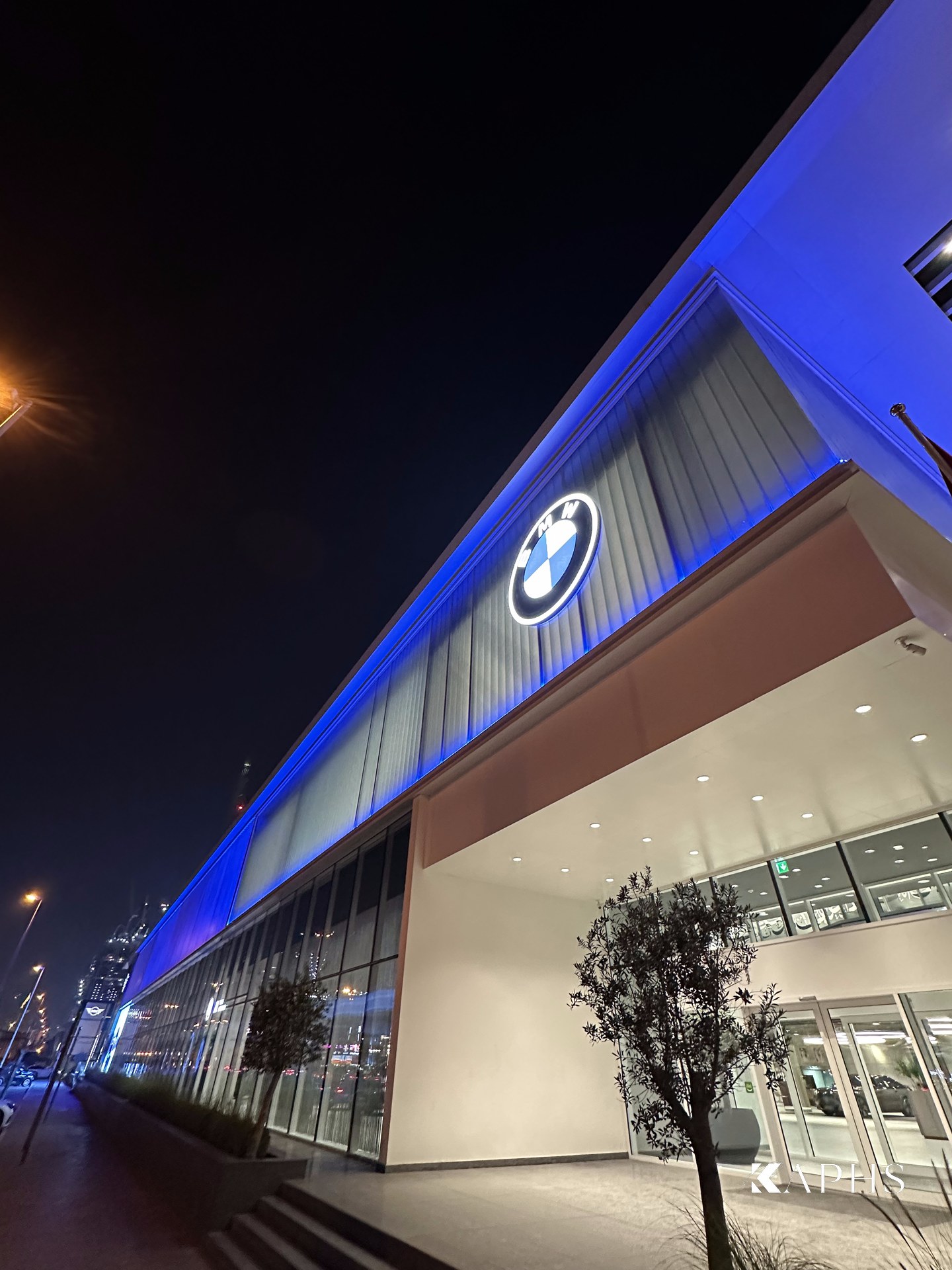 AGMC BMW showroom, Sheikh Zayed Road — upward view of the backlit LINIT U-channel glass façade at night, KAPHS