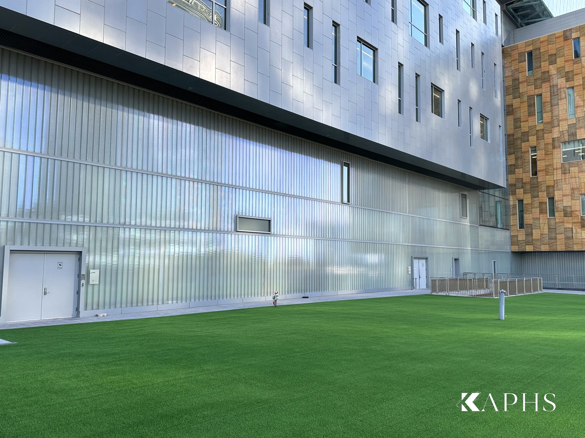 LINIT U-channel glass clad wall beside the courtyard lawn, Cleveland Clinic Abu Dhabi — KAPHS