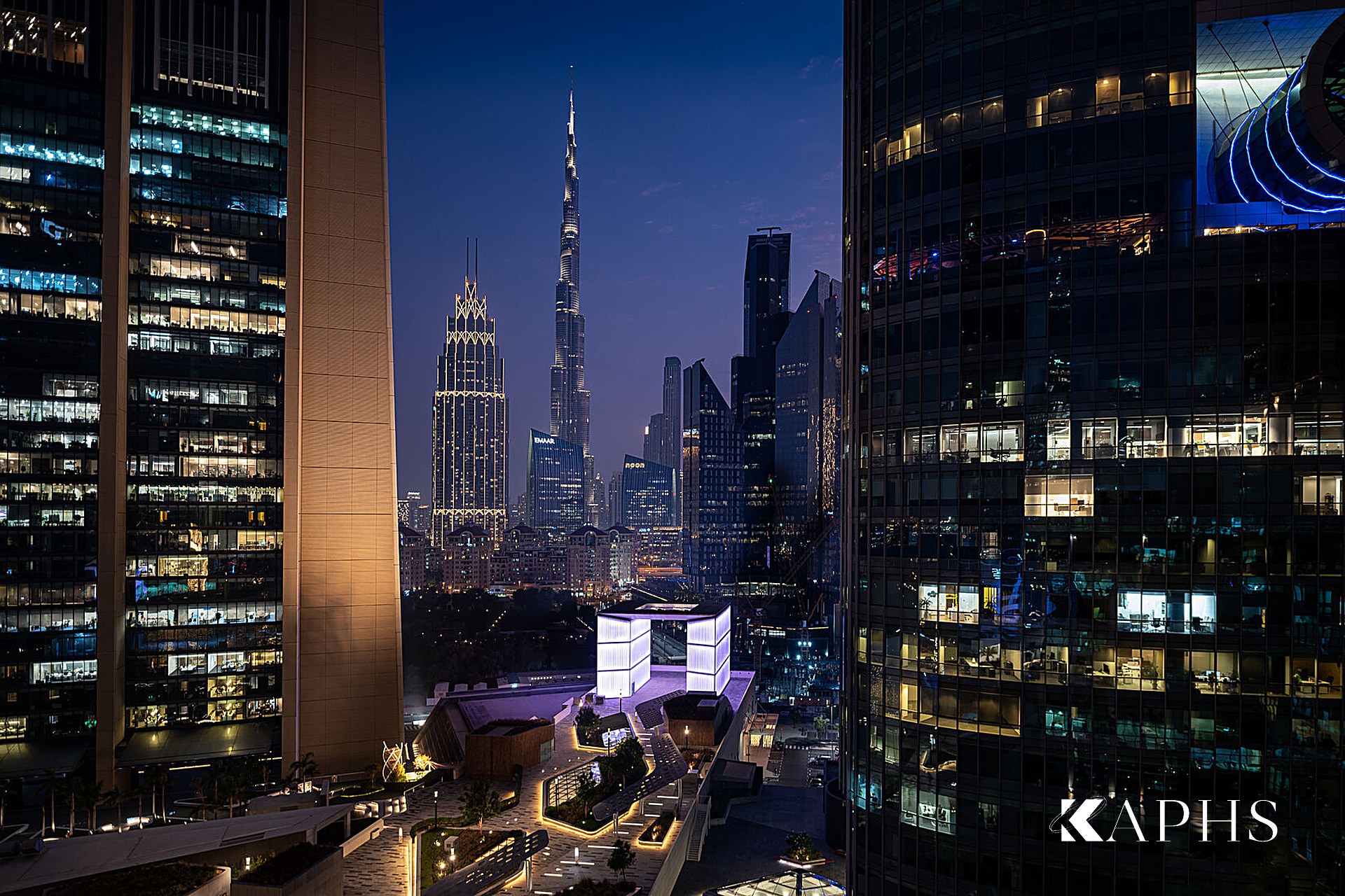 Illuminated DIFC Gate Avenue channel glass gateway against the Dubai skyline — KAPHS