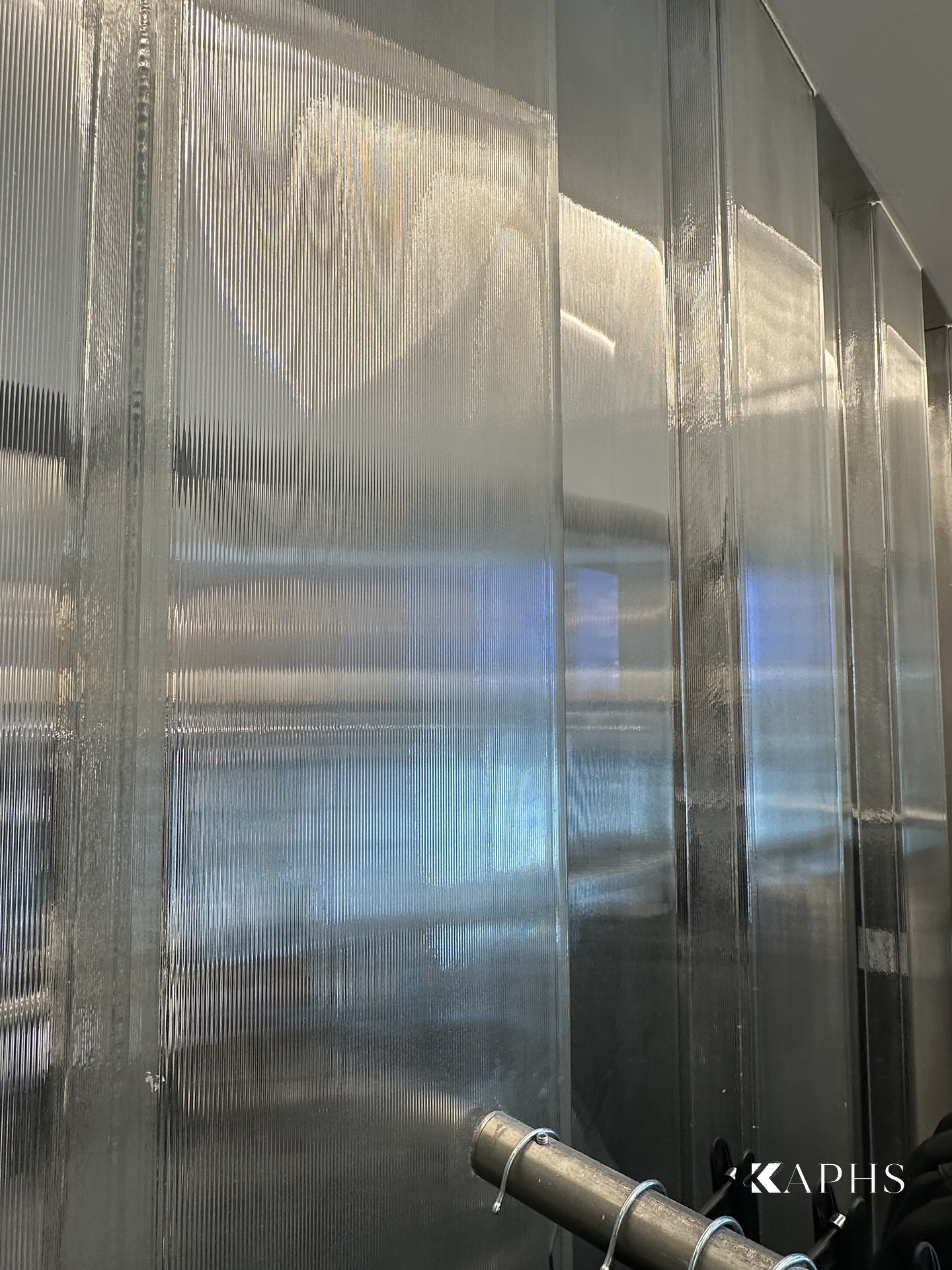 Translucent channel glass wall behind a mirrored fitting niche, H&M Yas Mall — KAPHS