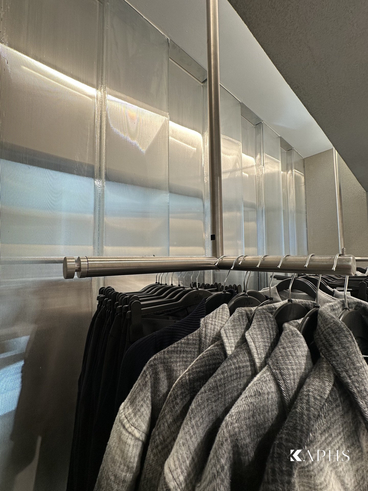 Backlit U-channel glass partition in the H&M Yas Mall menswear zone — KAPHS