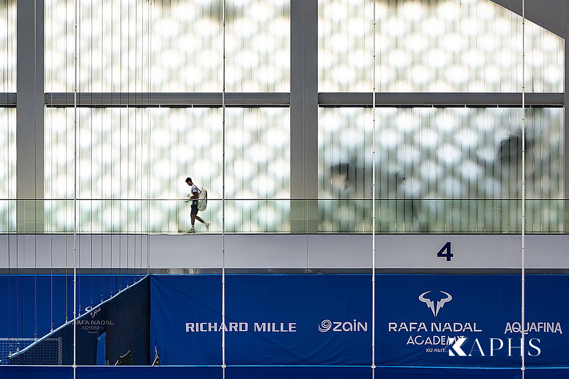 Kuwait International Tennis Complex interior with backlit U-channel glass wall — KAPHS